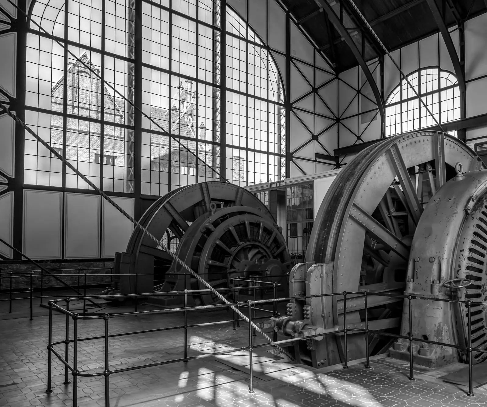 Large generators in a historic industrial machine hall with tall windows